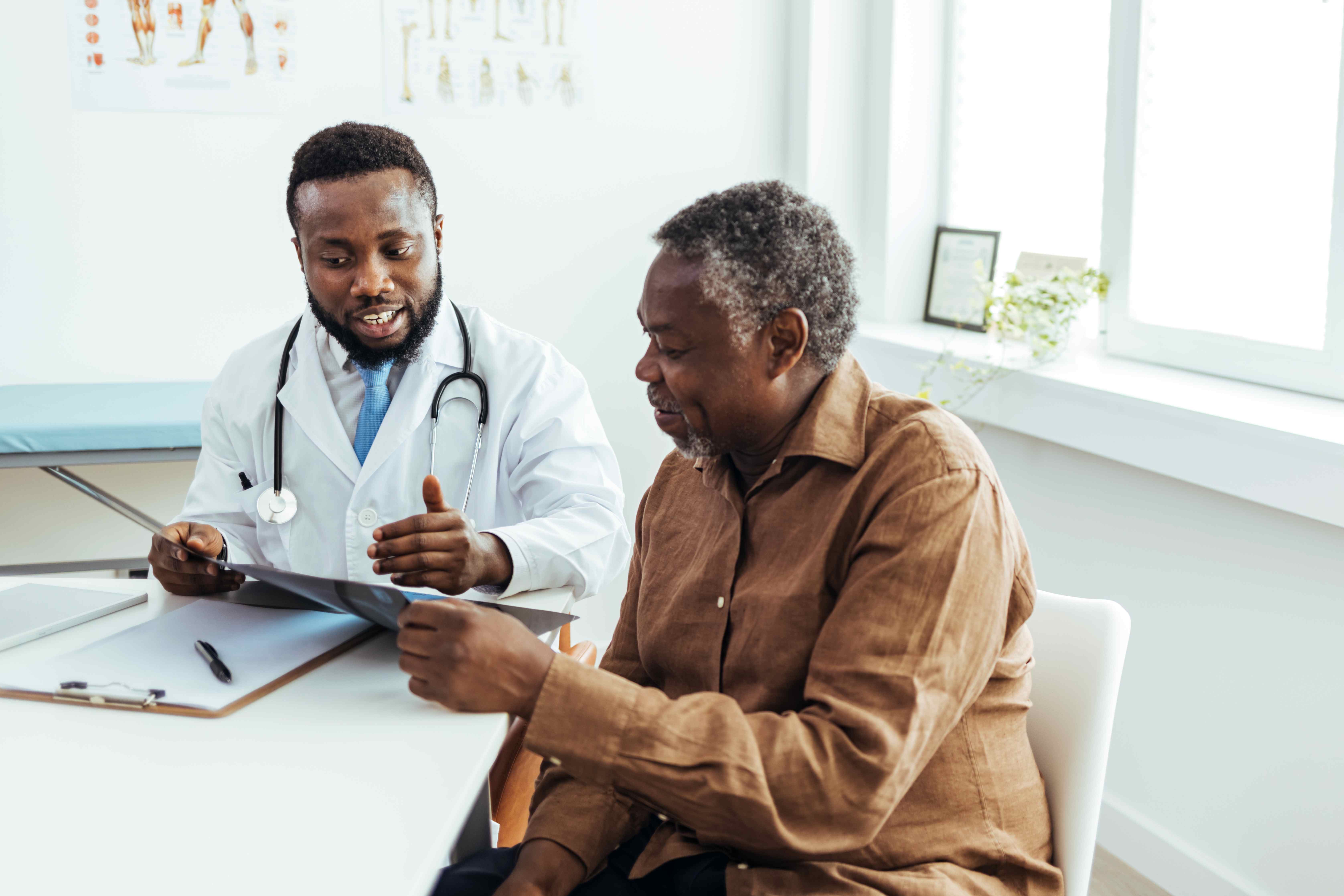 Black man with doctor discussing scan results