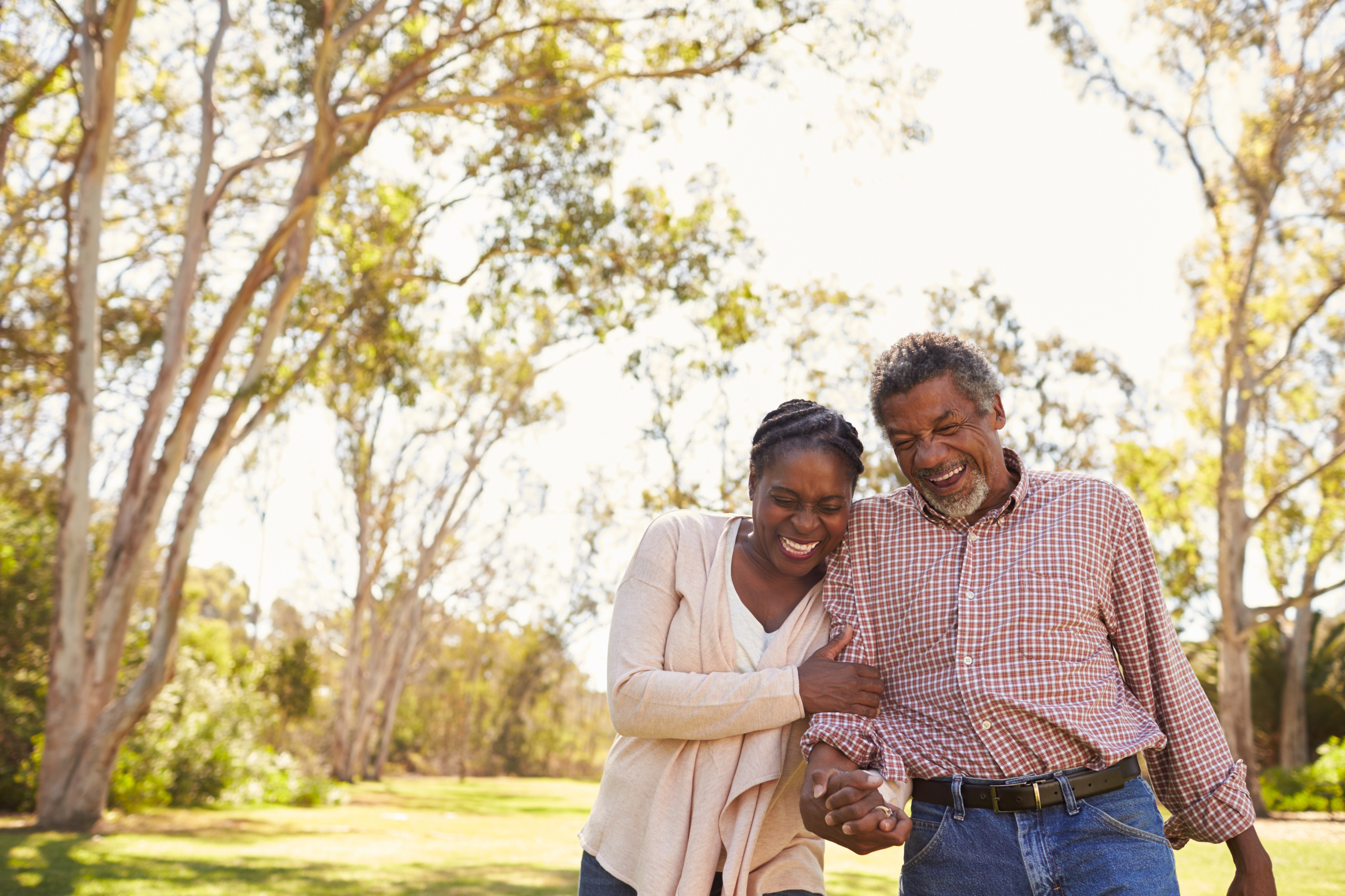 Couple arm in arm in park laughing