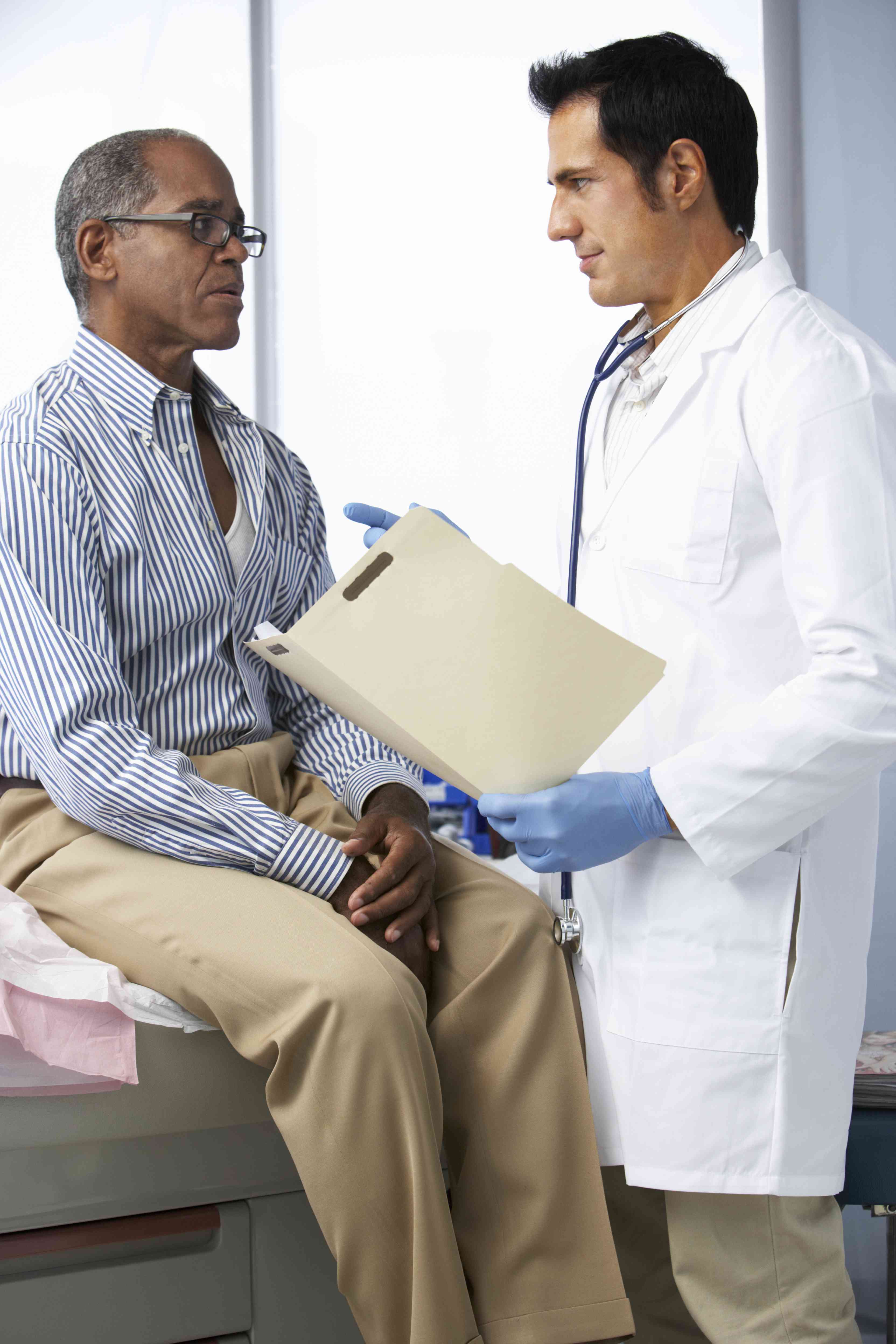 Black man talking  to doctor in white coat