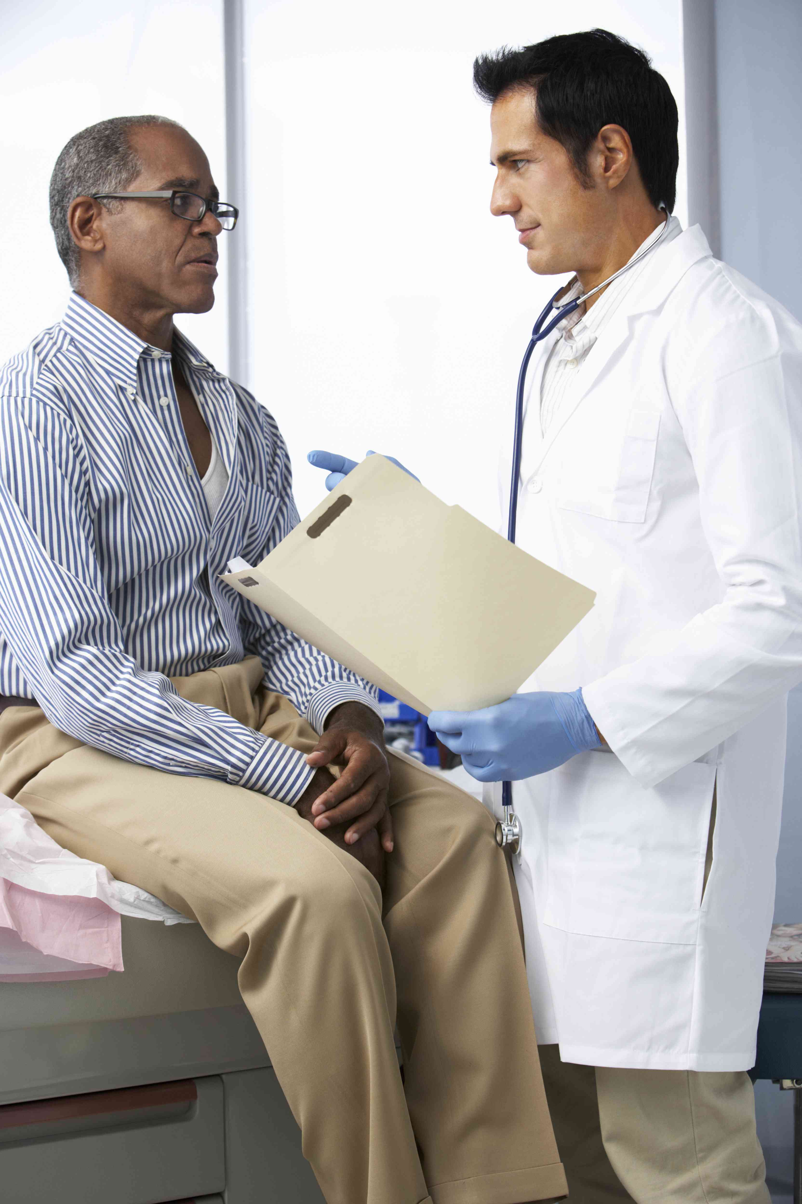 Black man speaking with doctor in White coat