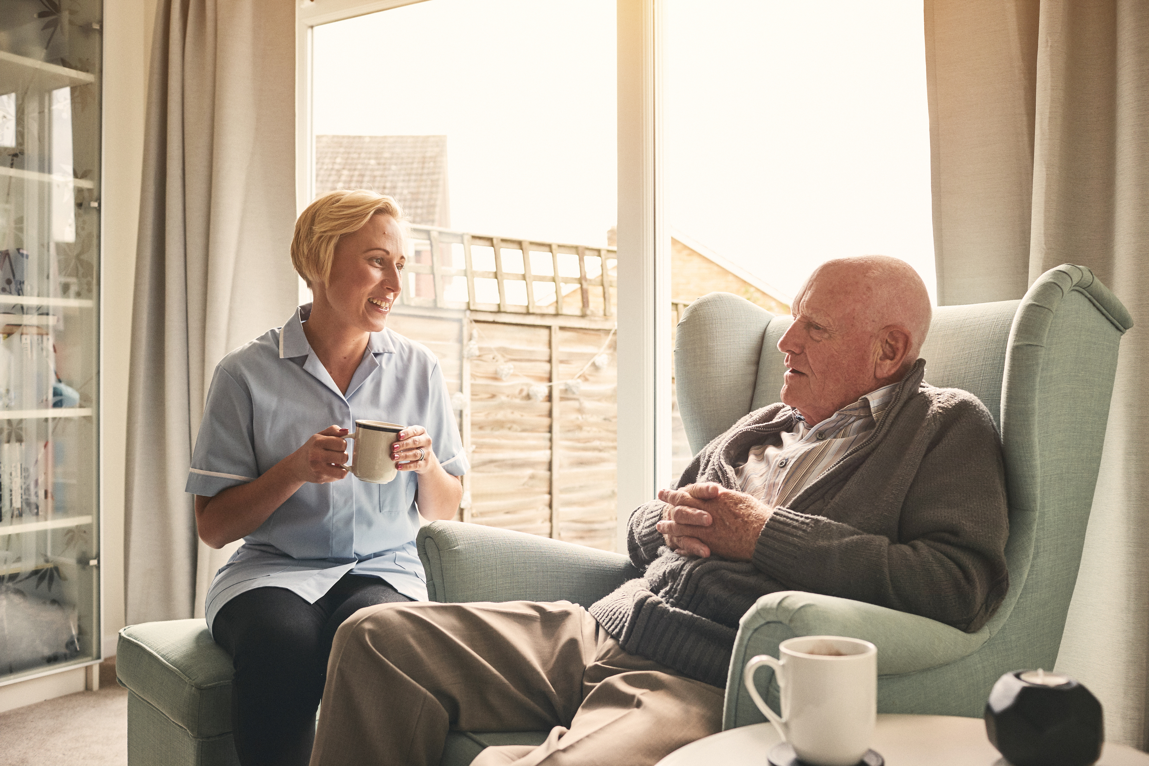 Nurse talking to older man in his own home