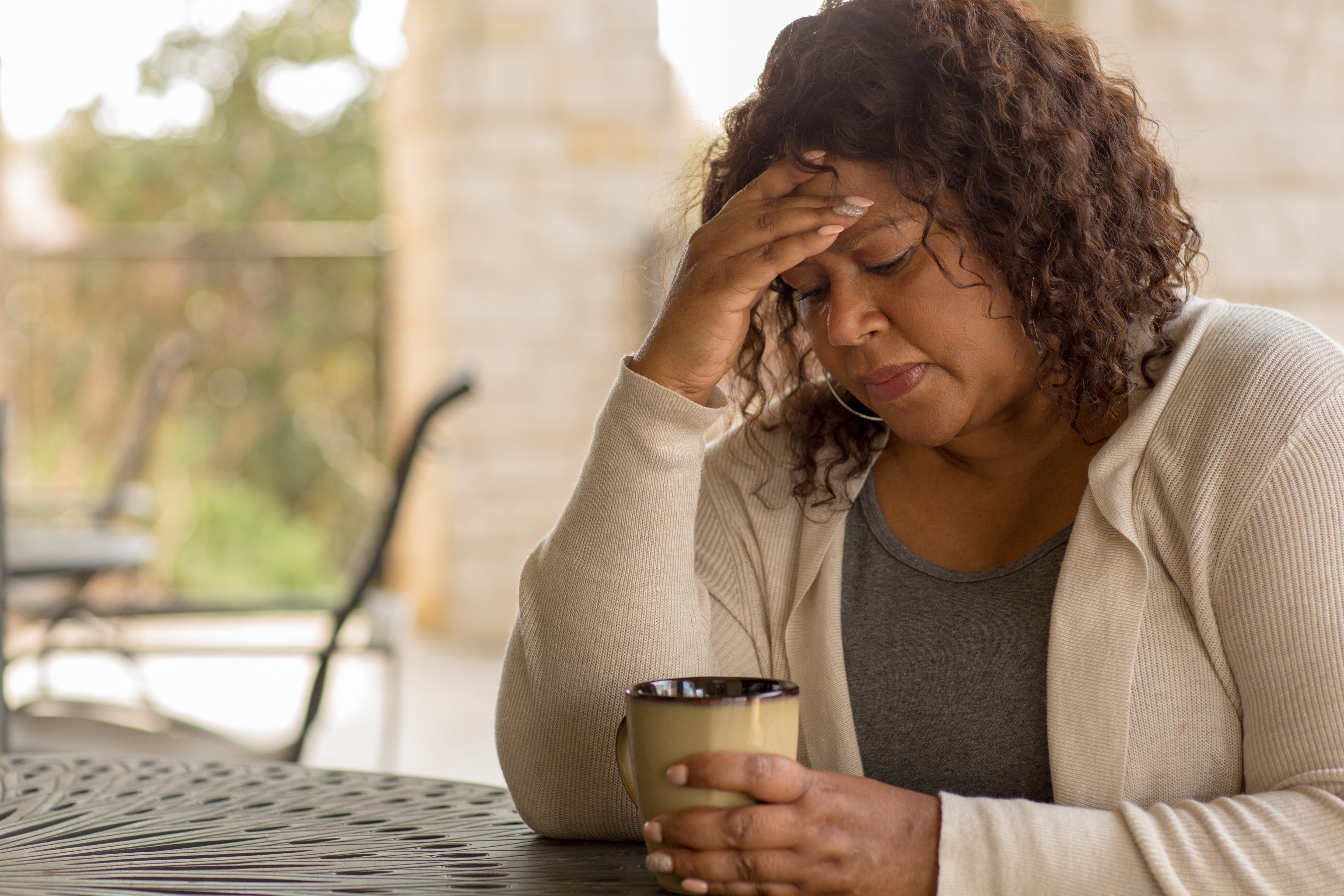 Woman looking down at coffee mug.