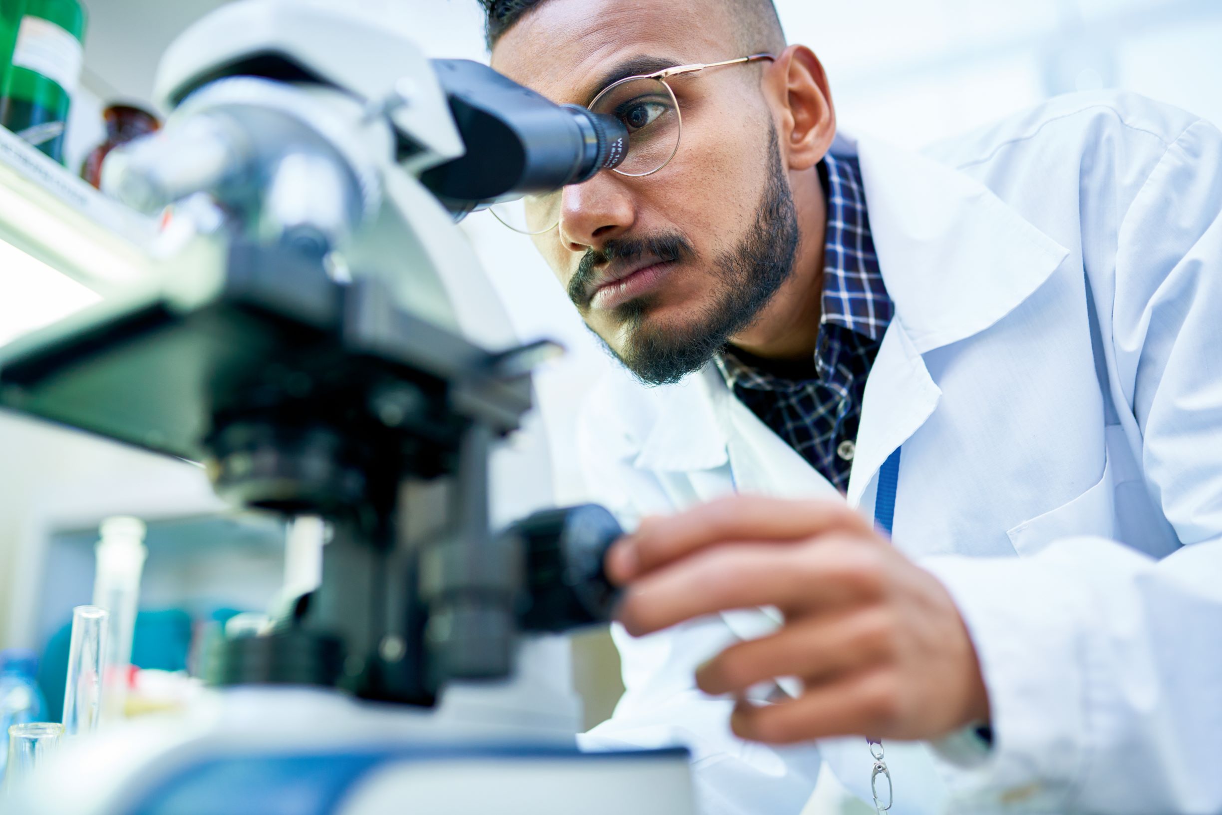 Scientist looking down microscope