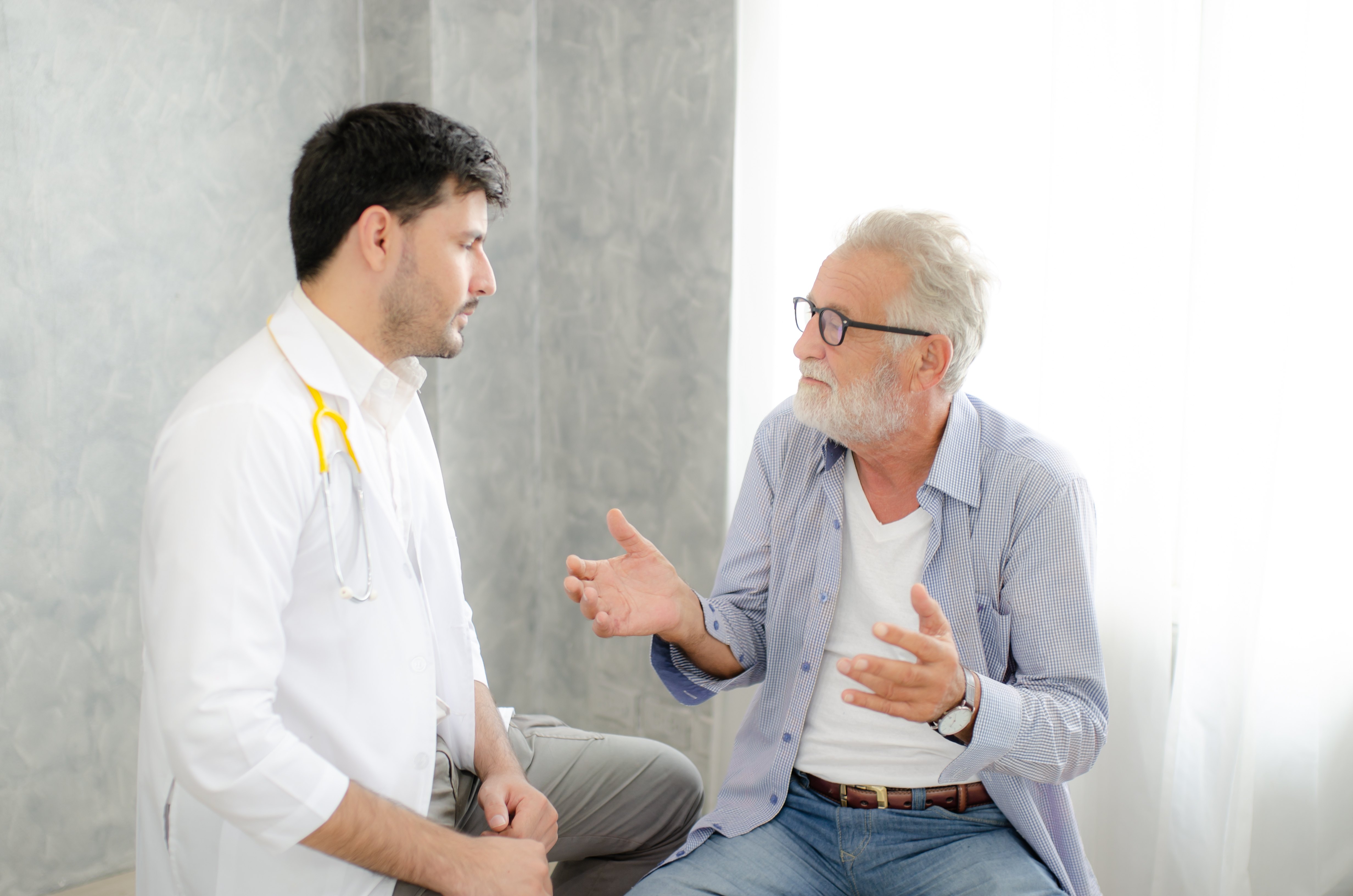 White man talking to White doctor in hospital clinic