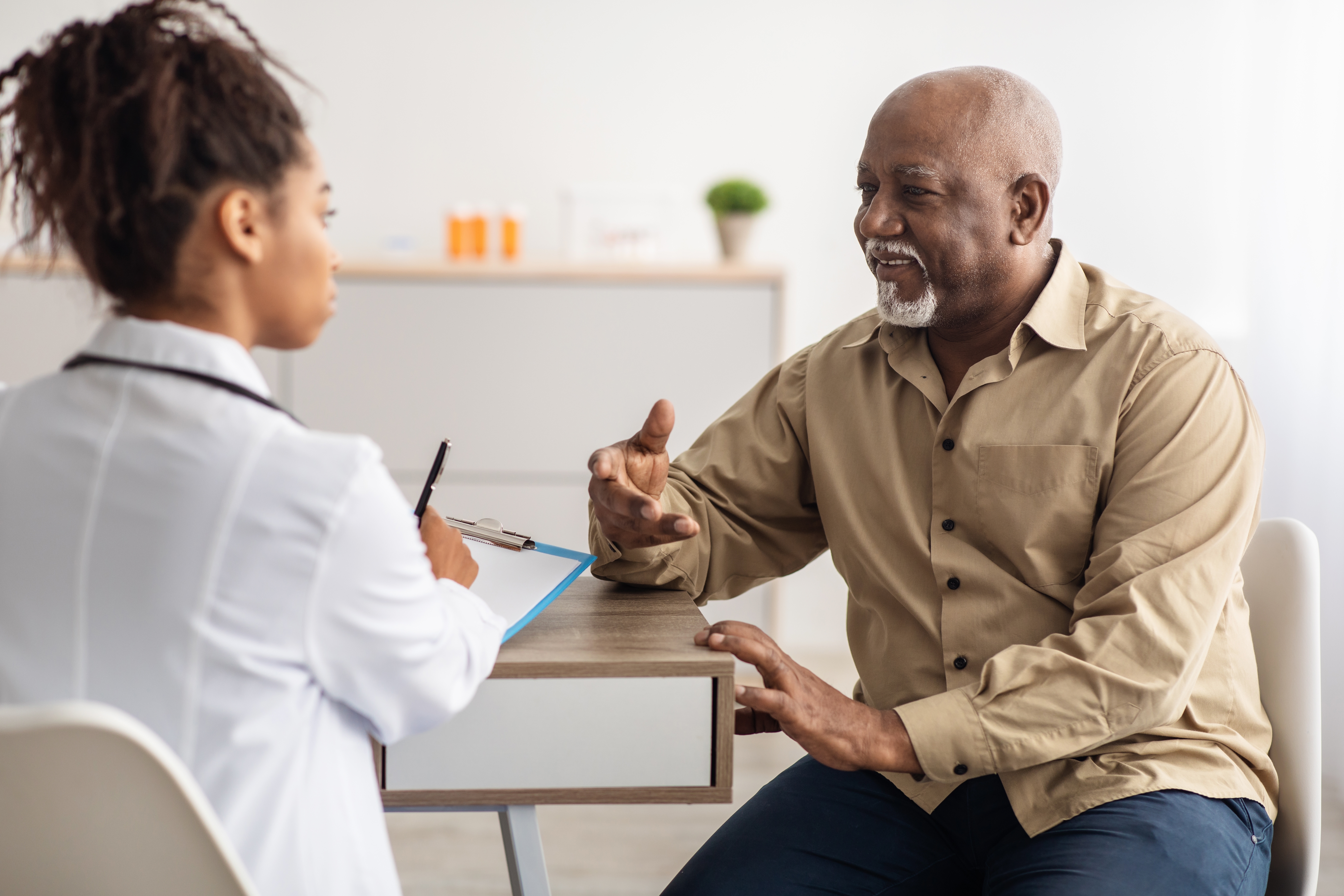 Black female doctor prescribing medication for a Black man